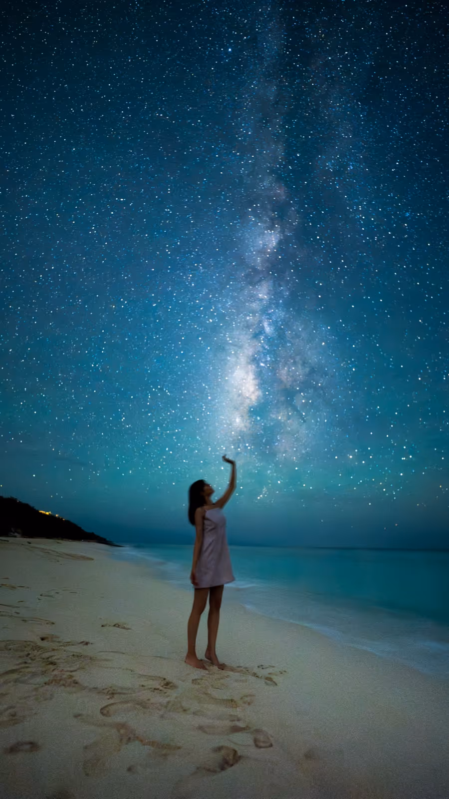 宮古島のビーチで天の川に手を伸ばす女性